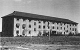 This building was called 'D Block' and housed mostly families. The paddock in front was often used by inmates to play soccer and at the back we each had a small plot to grow vegetables.